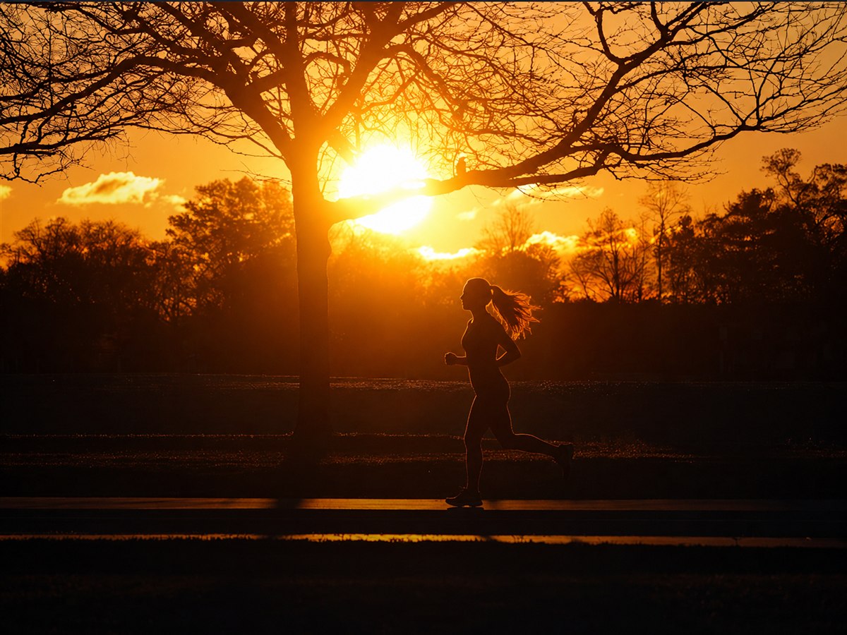 A runner silhouetted against a golden sunset